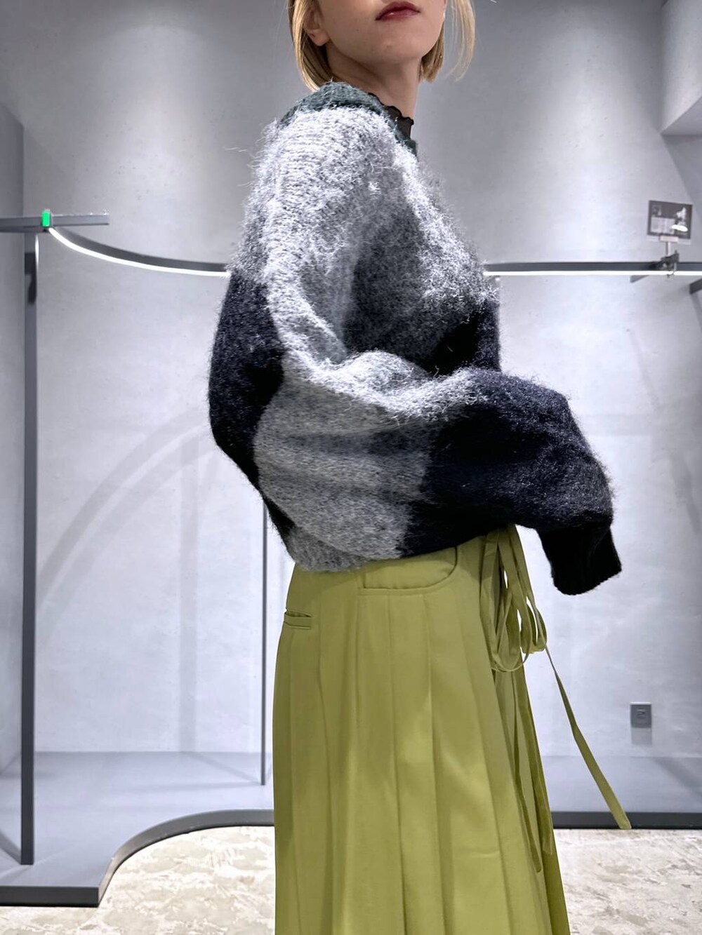 ブラック系のニット/セーター、グリーン系のその他パンツ、ブラック系のスニーカーを着用したレディースの冬コーディネートの5枚目の写真