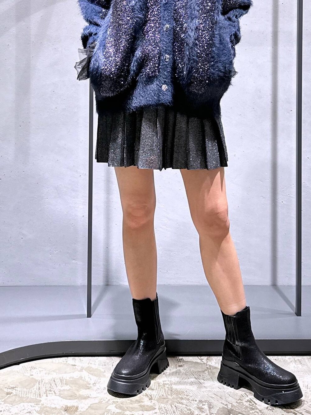 ブラック系のTシャツ/カットソー、ブラック系のブーツ、ブラック系のスカートを着用したレディースの冬コーディネートの6枚目の写真