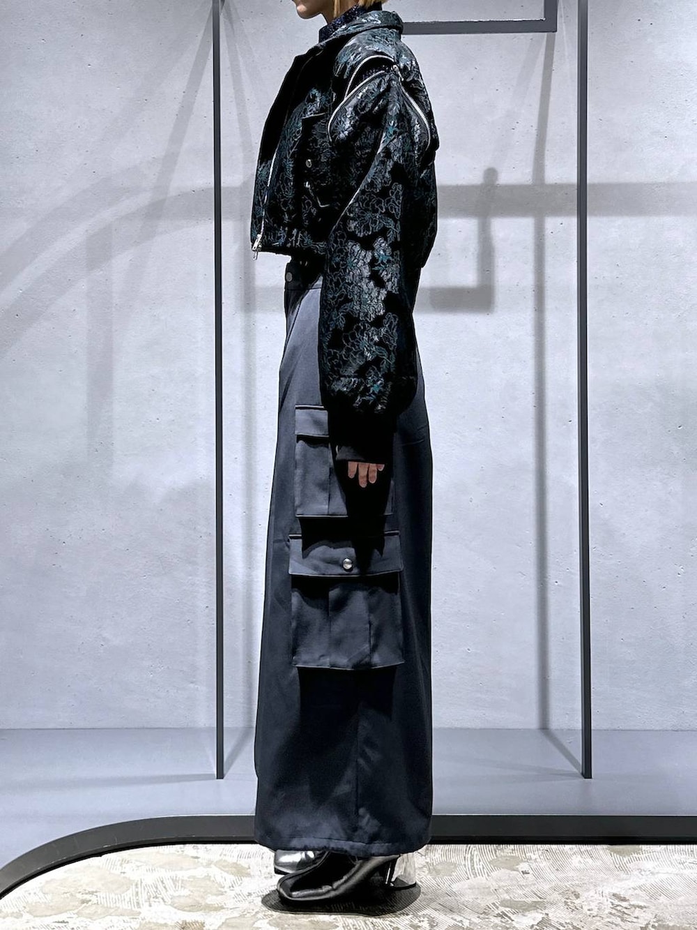 グリーン系のブルゾン、シルバー系のブーツ、ブルー系のニット/セーターを着用したレディースの秋コーディネートの2枚目の写真