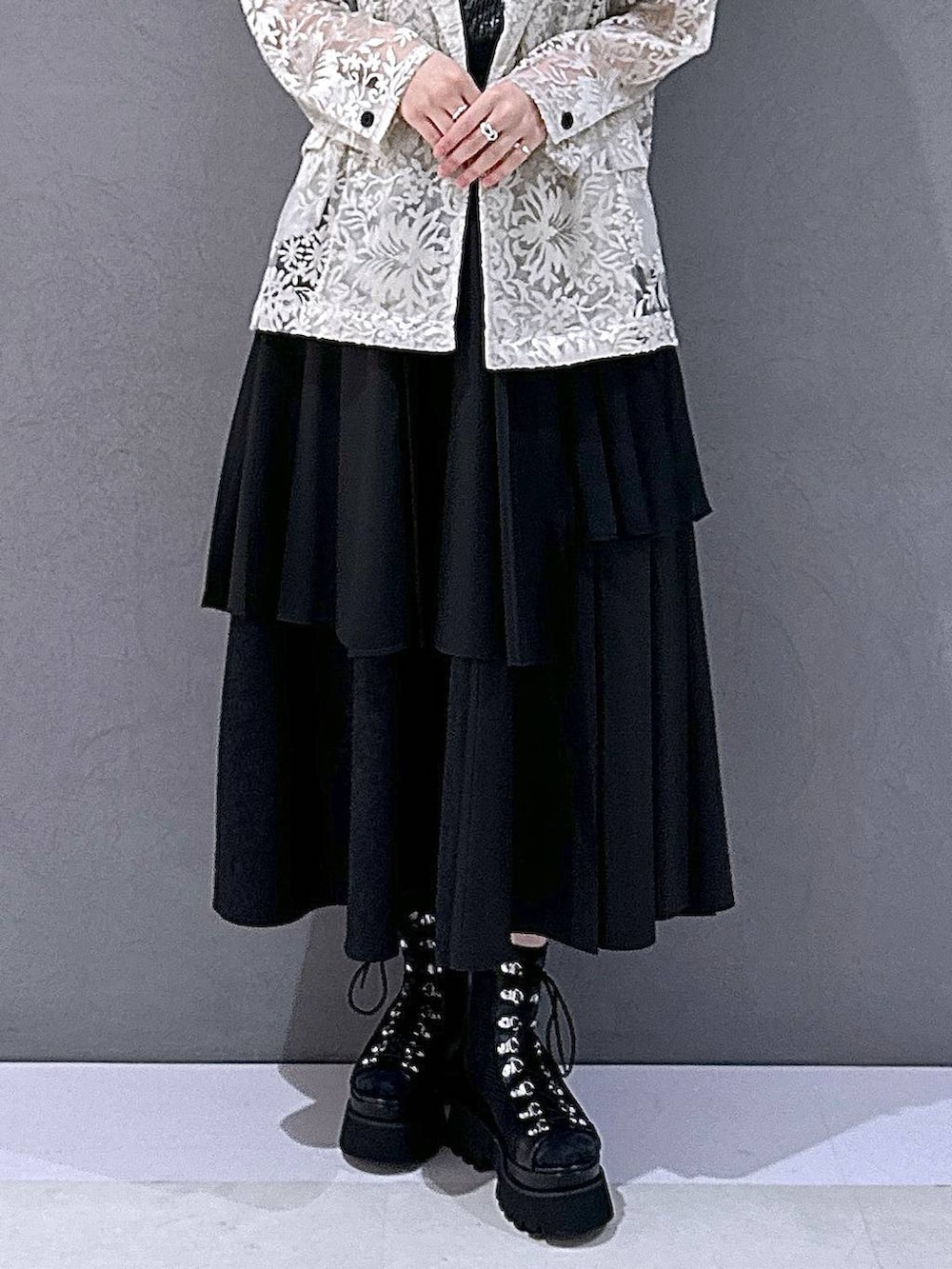 ブラック系のサンダル、ブラック系のTシャツ/カットソー、ホワイト系のテーラードジャケットを着用したレディースの夏コーディネートの6枚目の写真