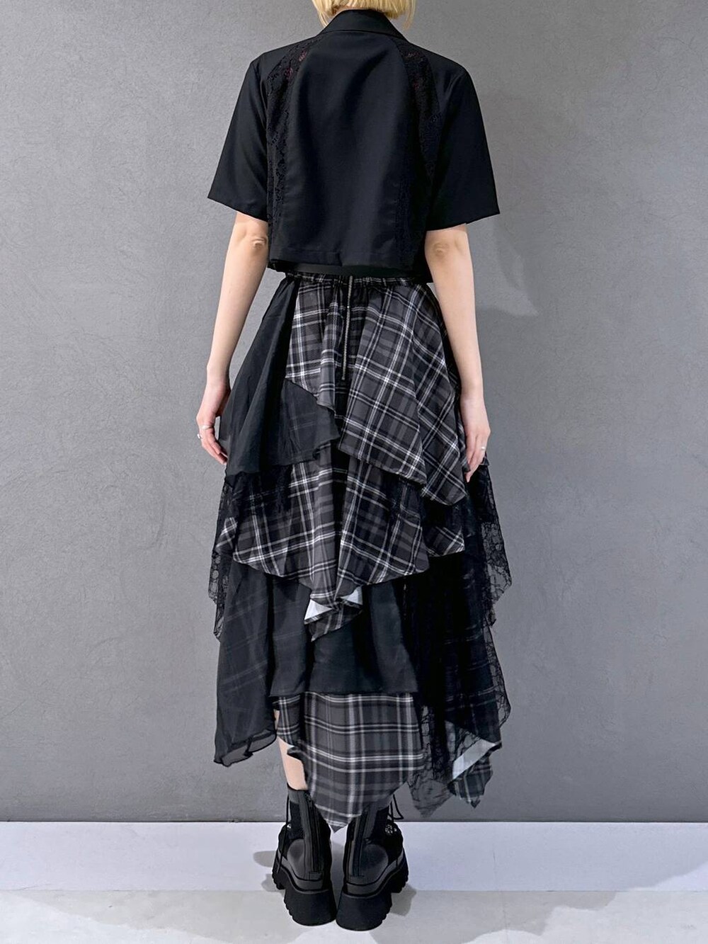 ブラック系のサンダル、ブラック系のテーラードジャケット、ブラック系のスカートを着用したレディースの春コーディネートの3枚目の写真