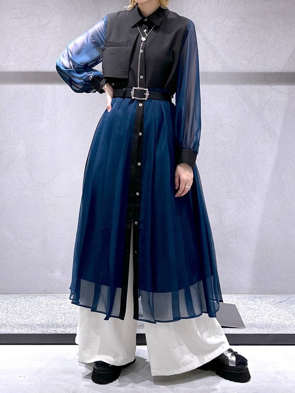 シルバー系のサンダル、ブラック系のワンピース、ホワイト系のスラックスを着用したレディースの春コーディネートの4枚目の写真