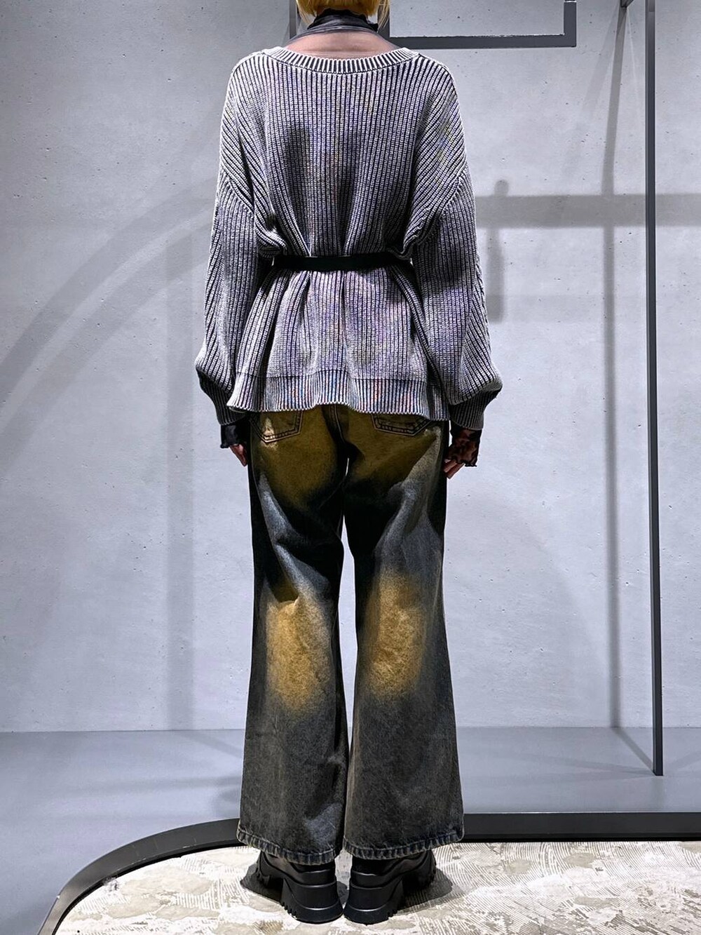 オレンジ系のデニムパンツ、ブラック系のブーツ、オレンジ系のTシャツ/カットソーを着用したレディースの秋コーディネートの3枚目の写真