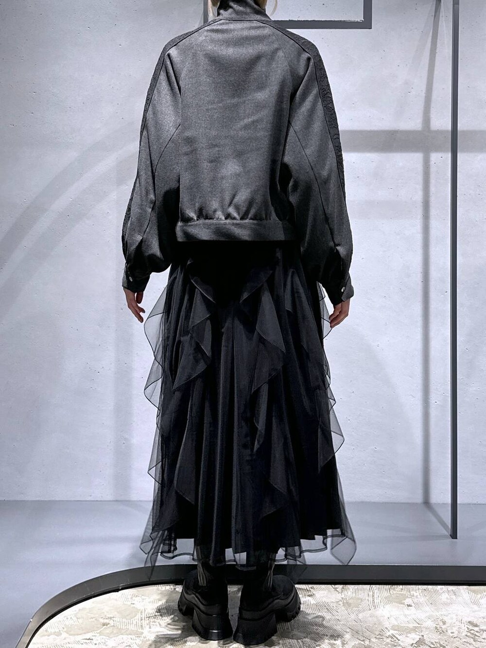 ブラック系のブーツ、イエロー系のカーディガン/ボレロ、グレー系のブルゾンを着用したレディースの冬コーディネートの3枚目の写真