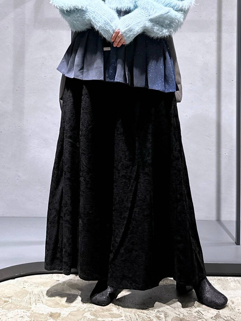 グリーン系のニット/セーター、ブラック系のブーツ、ブルー系のシャツ/ブラウスを着用したレディースの冬コーディネートの6枚目の写真