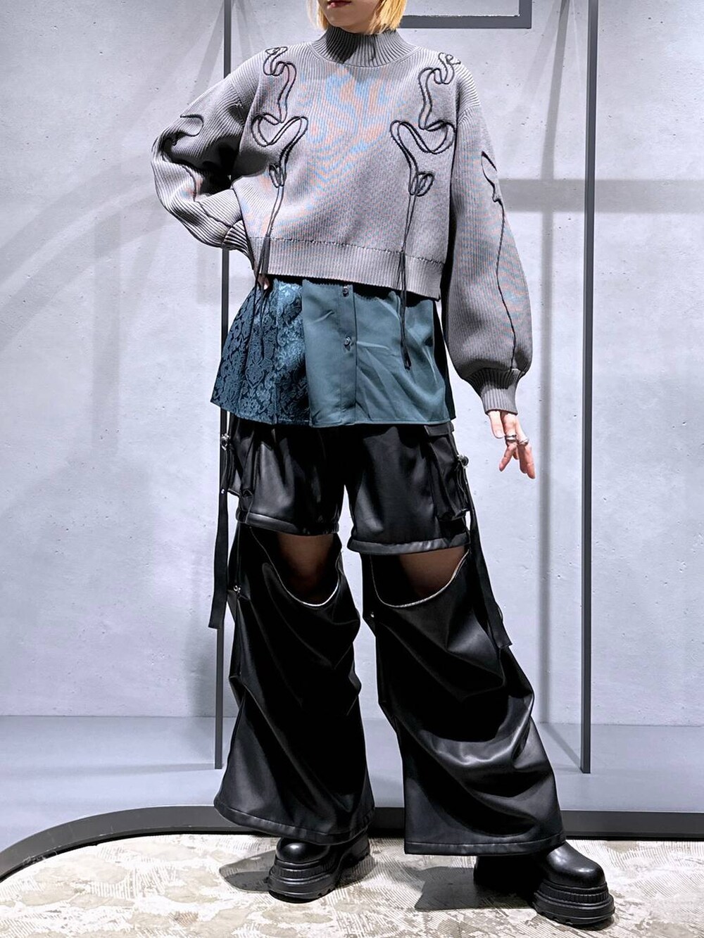 ブラック系のカーゴパンツ、ブラック系のブーツ、グレー系のニット/セーターを着用したレディースの冬コーディネートの4枚目の写真