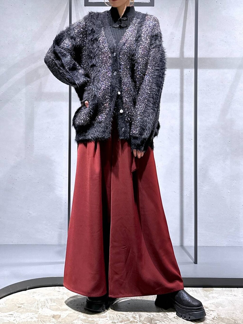 レッド系のその他パンツ、ブラック系のブーツ、ブラック系のニット/セーターを着用したレディースの冬コーディネートの4枚目の写真