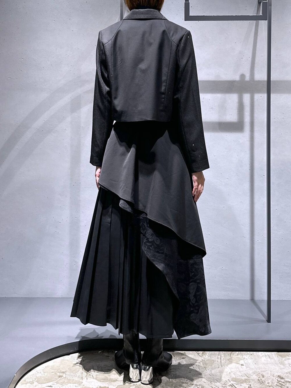 ブラック系のスカート、ブルー系のニット/セーター、ブラック系のブーツを着用したレディースの秋コーディネートの3枚目の写真