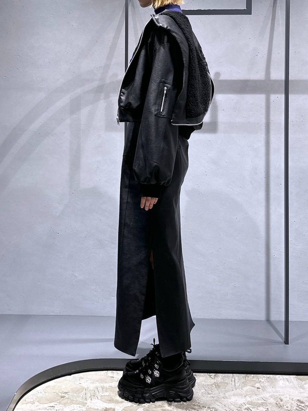 ブラック系のスニーカー、ブラック系のスカート、パープル系のニット/セーターを着用したレディースの冬コーディネートの2枚目の写真