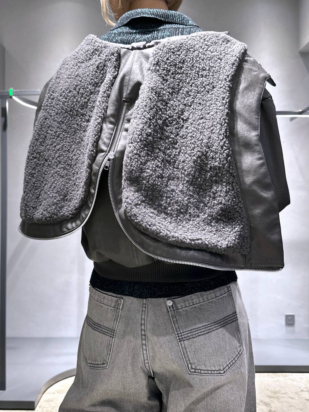 ブラック系のブーツ、グリーン系のカーディガン/ボレロ、グレー系のデニムパンツを着用したレディースの冬コーディネートの6枚目の写真