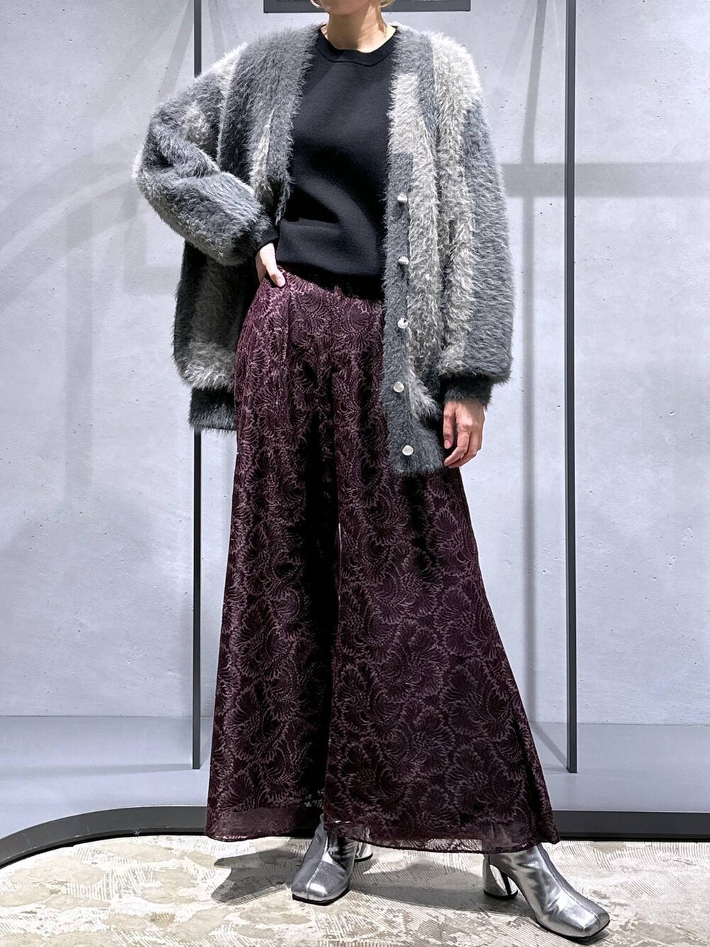 グレー系のカーディガン/ボレロ、シルバー系のブーツ、ブラック系のニット/セーターを着用したレディースの秋コーディネートの4枚目の写真