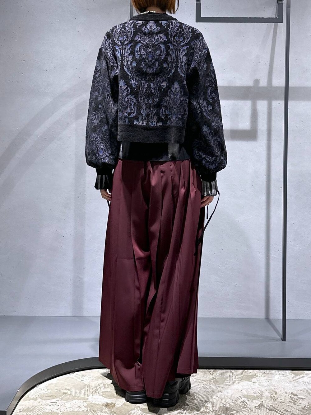 ブラック系のニット/セーター、ブラック系のローファー、レッド系のその他パンツを着用したレディースの秋コーディネートの3枚目の写真