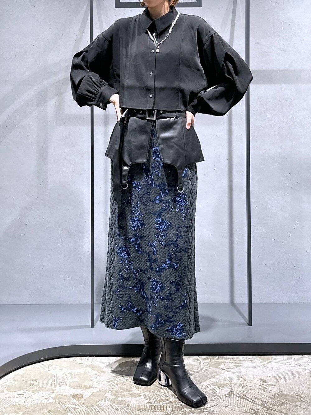 グレー系のスカート、ブラック系のブーツ、ブラック系のシャツ/ブラウスを着用したレディースの秋コーディネートの4枚目の写真