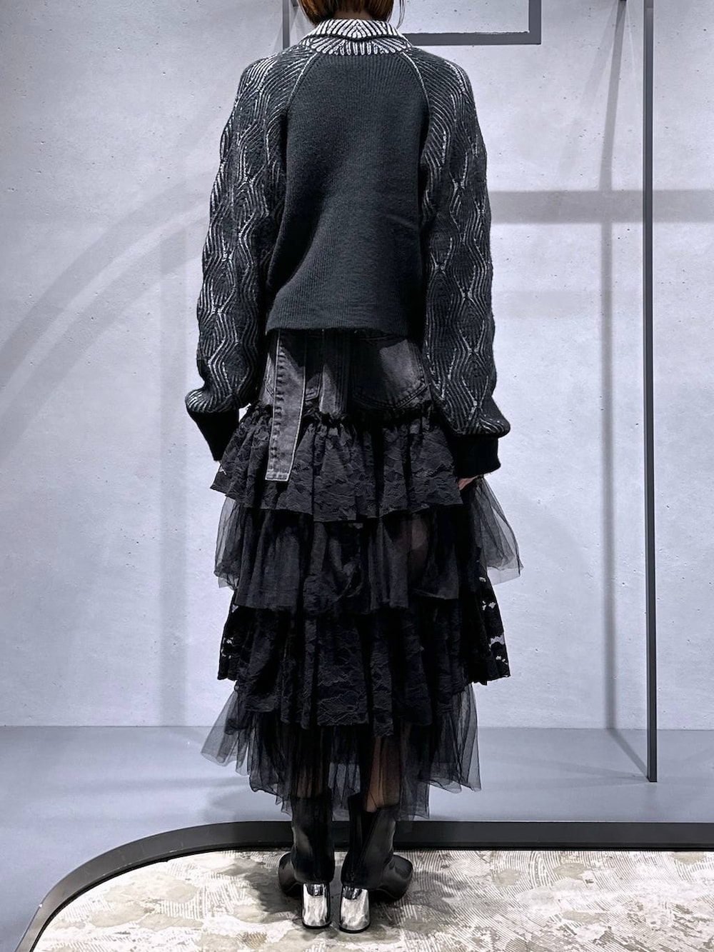 ブラック系のブーツ、ブラック系のカーディガン/ボレロ、レッド系のニット/セーターを着用したレディースの秋コーディネートの3枚目の写真