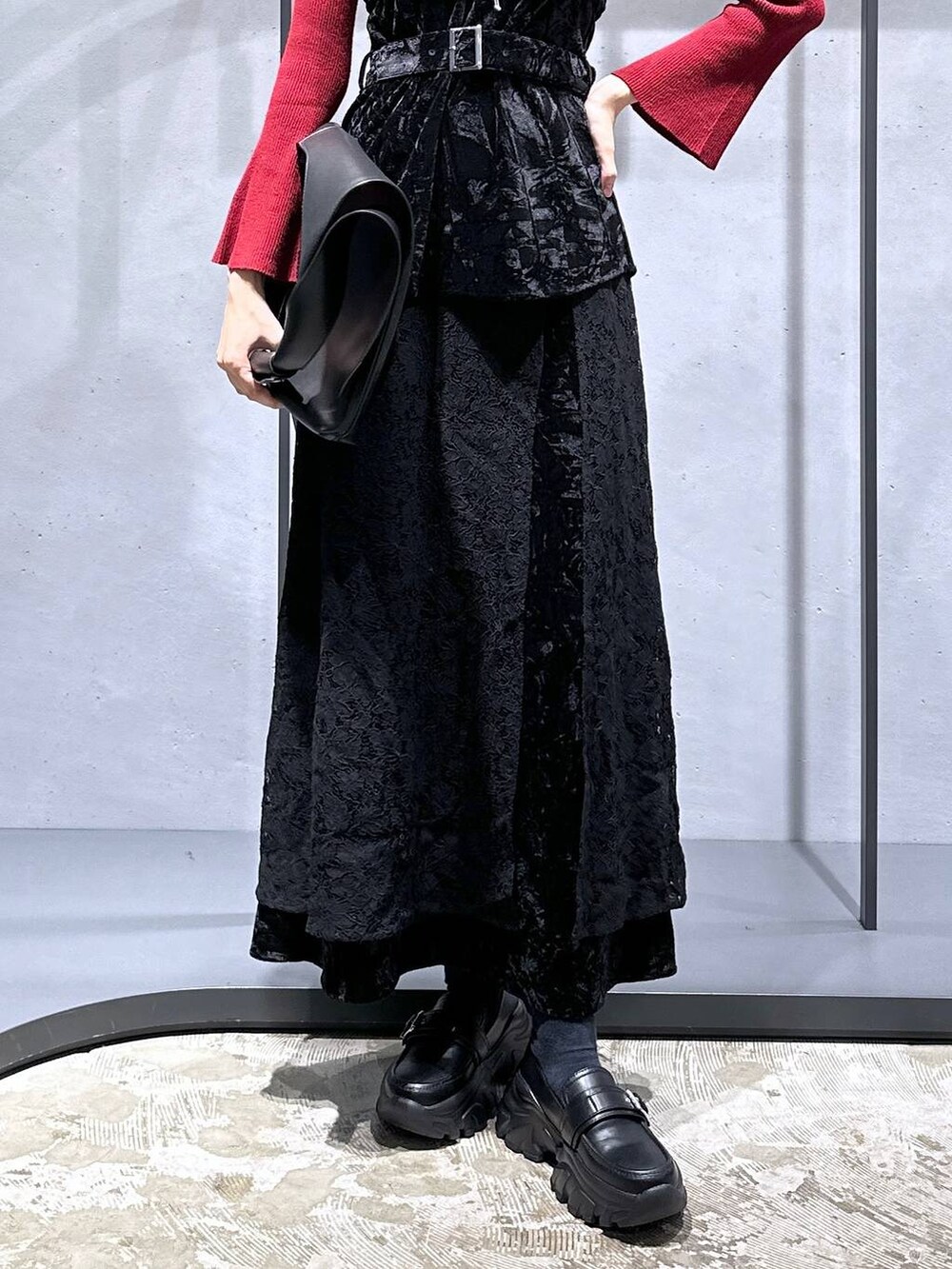 レッド系のニット/セーター、ブラック系のローファー、ブラック系のベストを着用したレディースの夏コーディネートの7枚目の写真