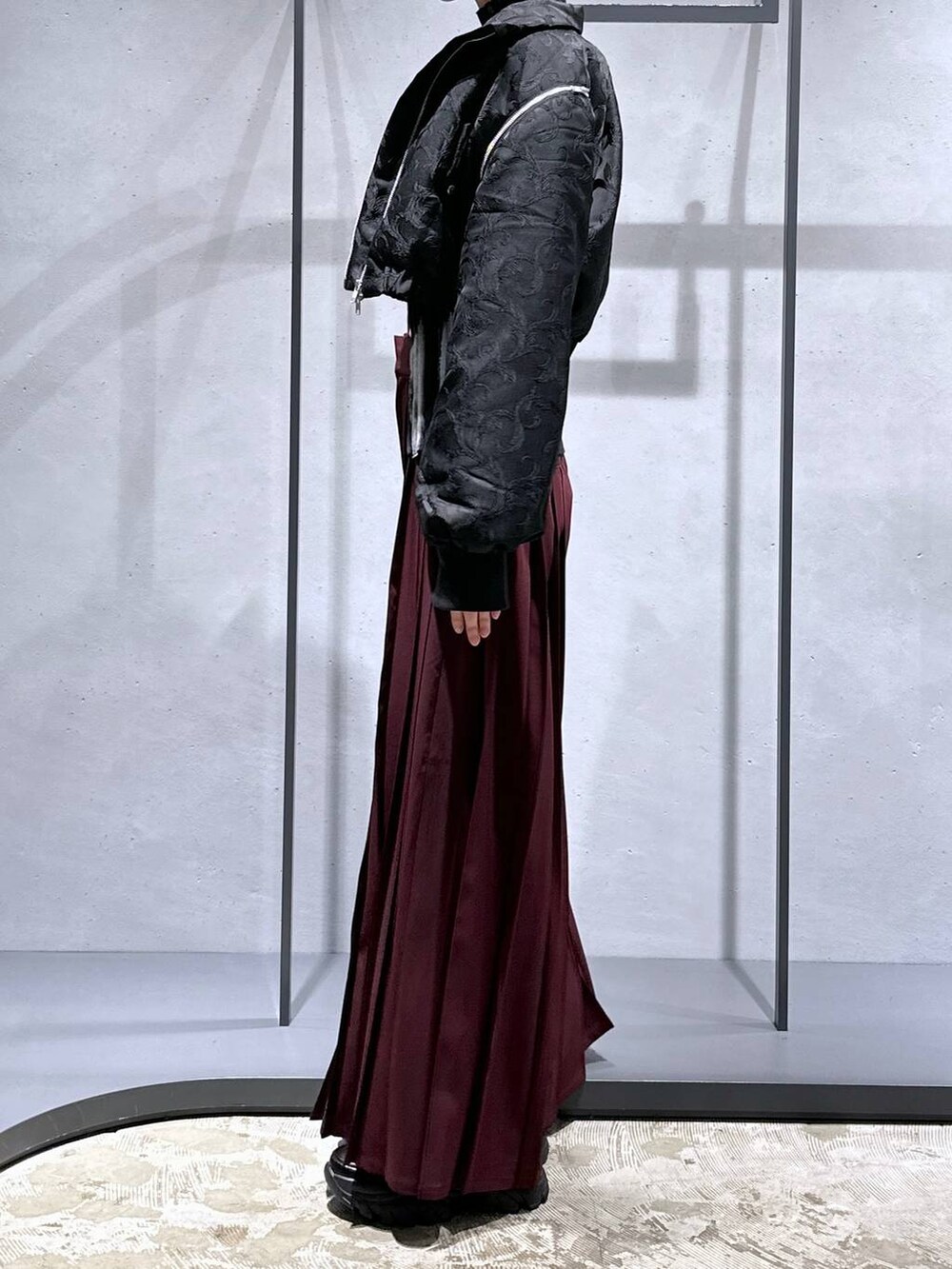 ブラック系のブルゾン、レッド系のその他パンツ、ブラック系のローファーを着用したレディースの秋コーディネートの2枚目の写真