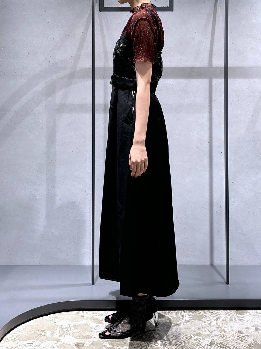 ブラック系のサンダル、レッド系のTシャツ/カットソー、ブラック系のジャンパースカートを着用したレディースの夏コーディネートの2枚目の写真