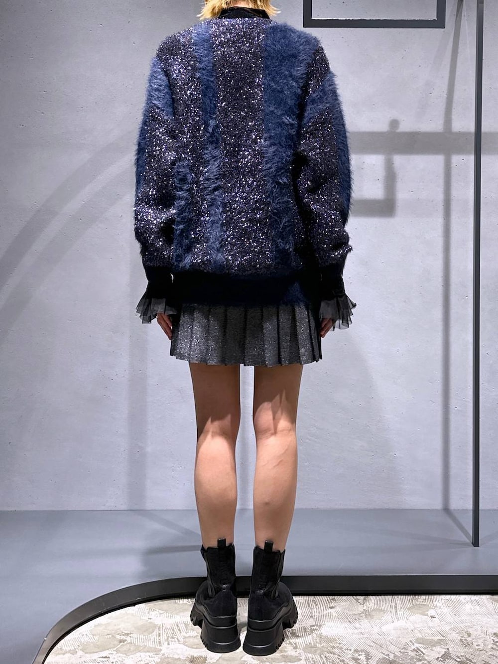 ブラック系のTシャツ/カットソー、ブラック系のブーツ、ブラック系のスカートを着用したレディースの冬コーディネートの3枚目の写真