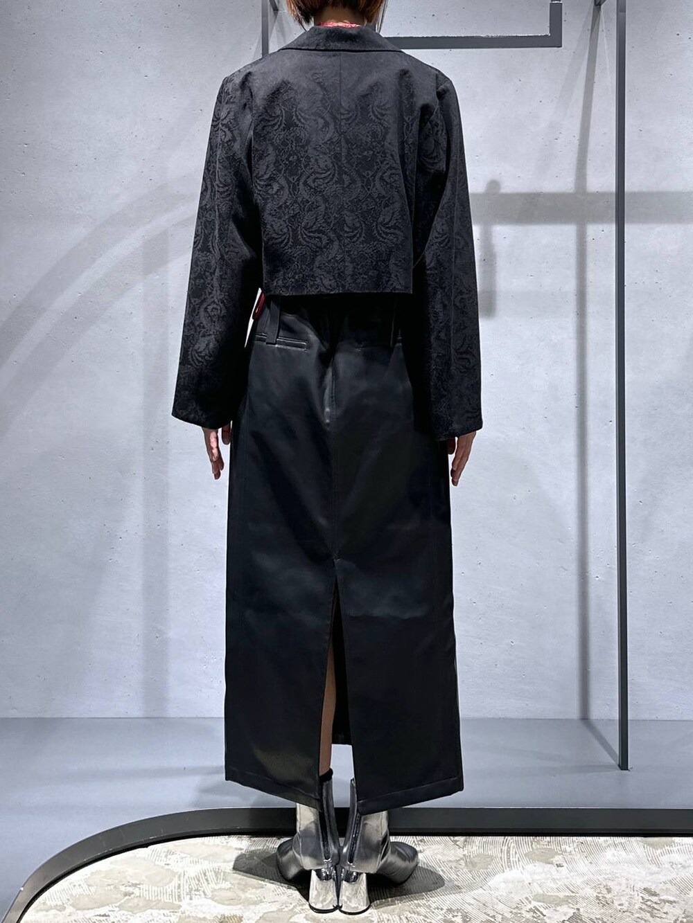 シルバー系のブーツ、レッド系のTシャツ/カットソー、ブラック系のテーラードジャケットを着用したレディースの秋コーディネートの3枚目の写真