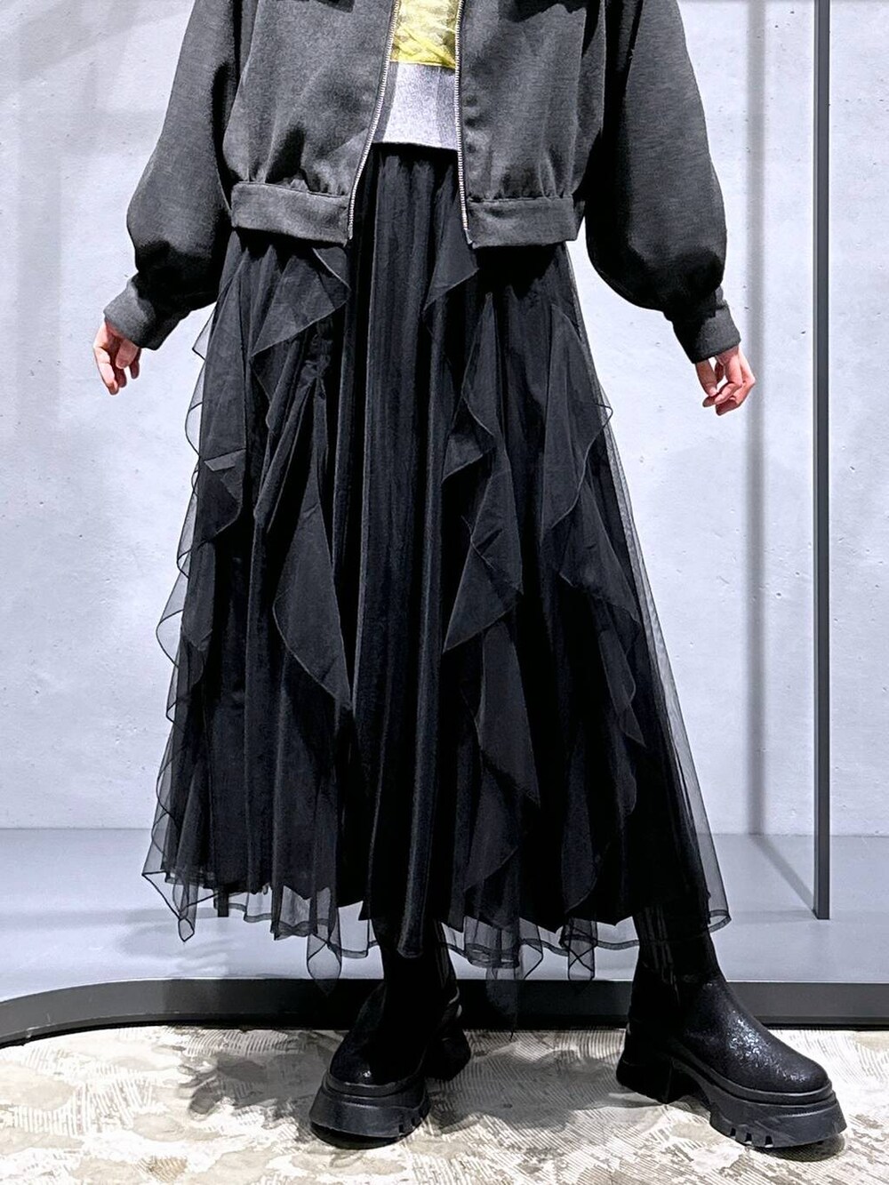 ブラック系のブーツ、イエロー系のカーディガン/ボレロ、グレー系のブルゾンを着用したレディースの冬コーディネートの6枚目の写真