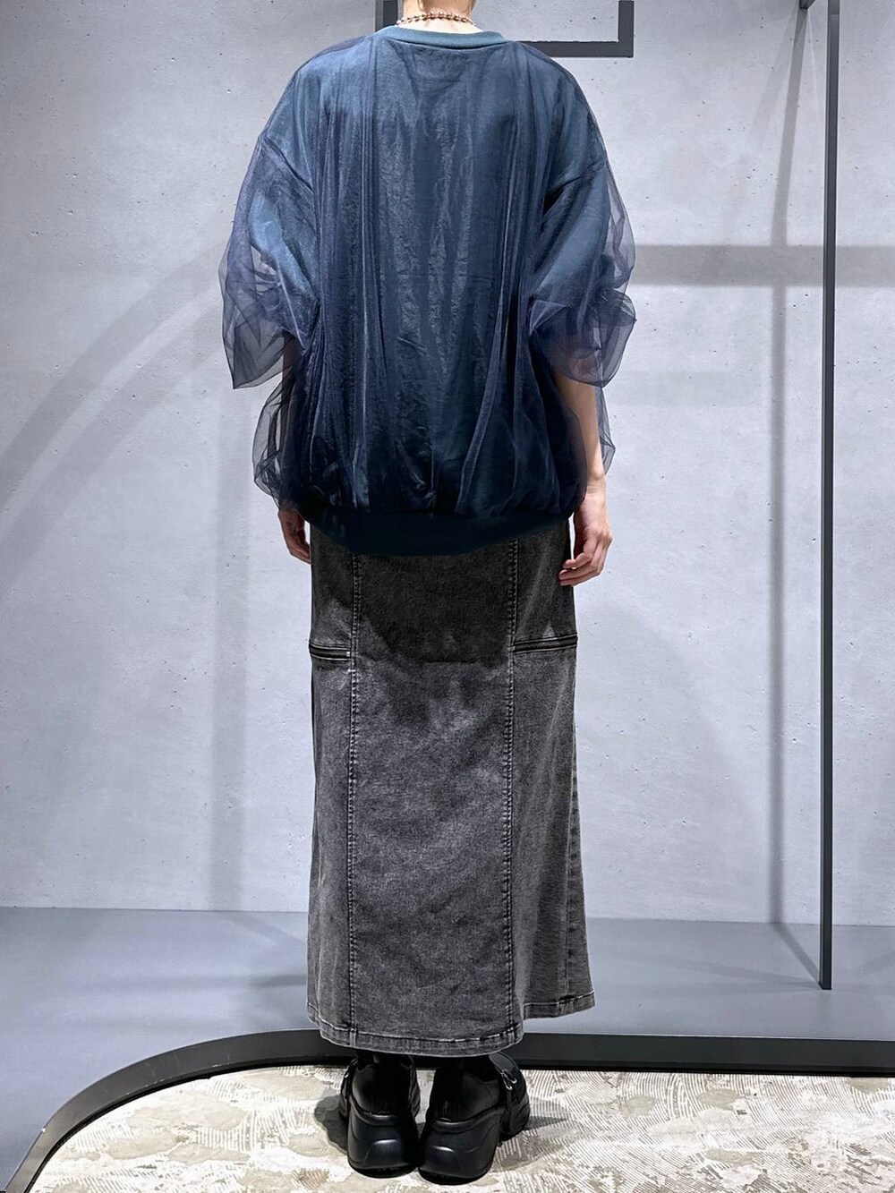 グリーン系のスウェット、ブラック系のブーツ、ブラック系のスカートを着用したレディースの夏コーディネートの3枚目の写真