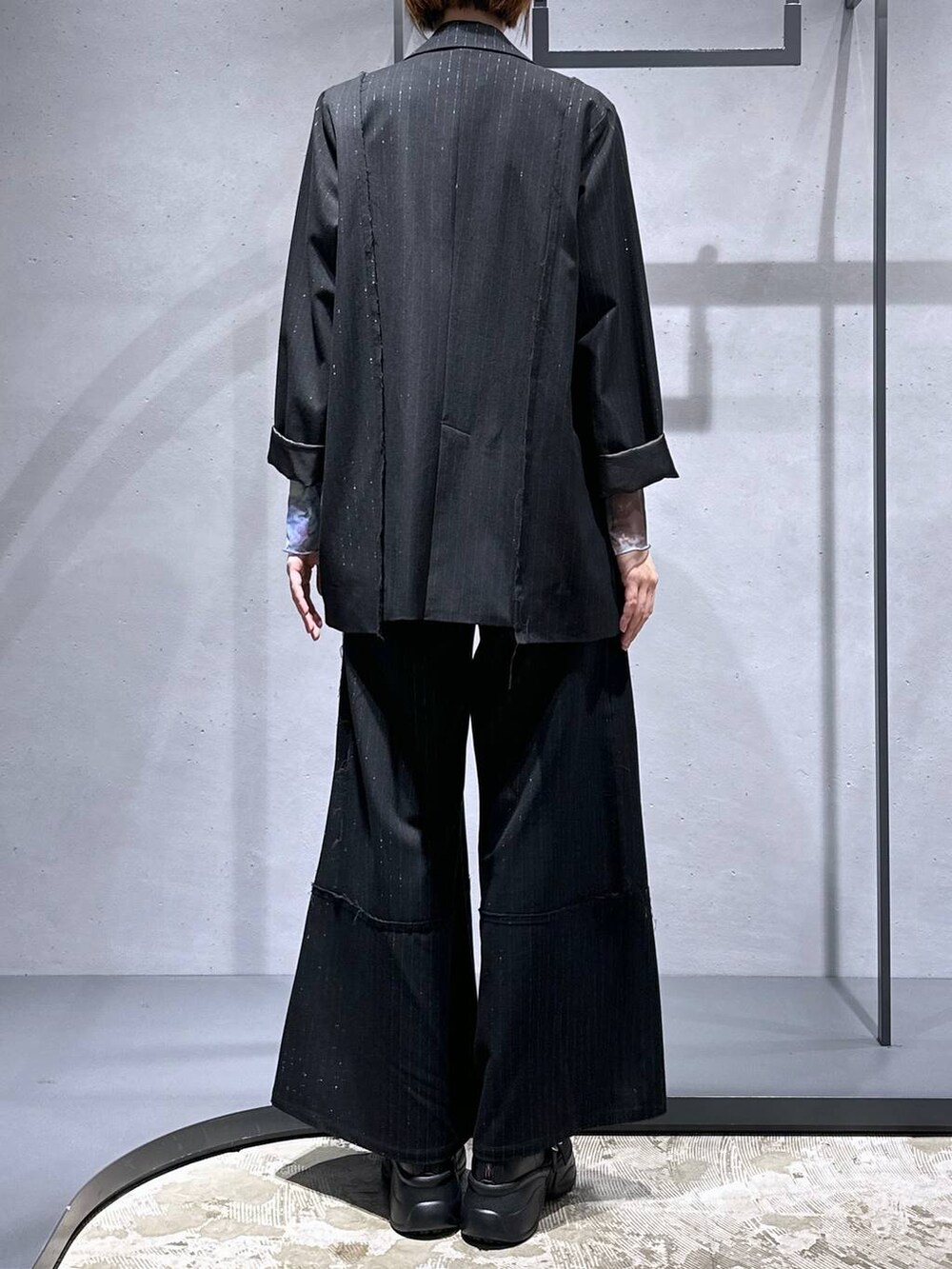 パープル系のTシャツ/カットソー、ブラック系のブーツ、ブラック系のテーラードジャケットを着用したレディースの秋コーディネートの3枚目の写真