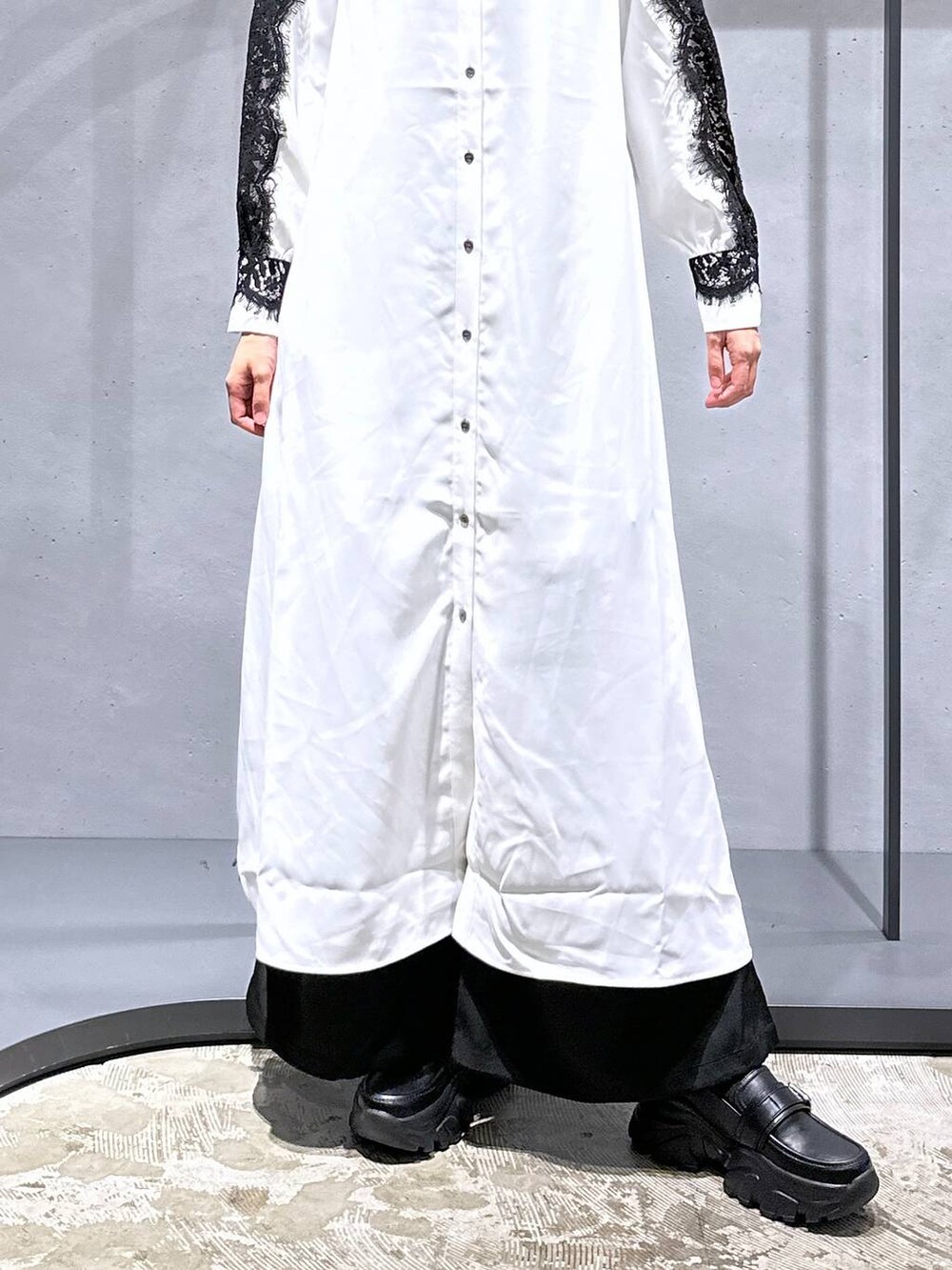 ブラック系のカーゴパンツ、ホワイト系のワンピース、ブラック系のローファーを着用したレディースの秋コーディネートの6枚目の写真