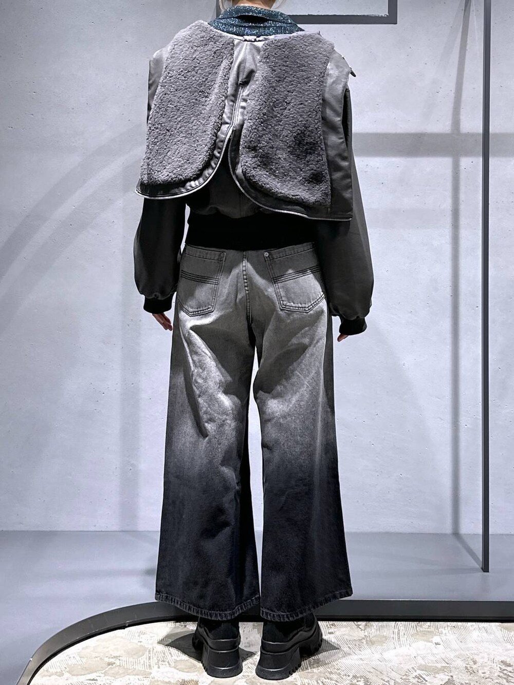 ブラック系のブーツ、グリーン系のカーディガン/ボレロ、グレー系のデニムパンツを着用したレディースの冬コーディネートの3枚目の写真