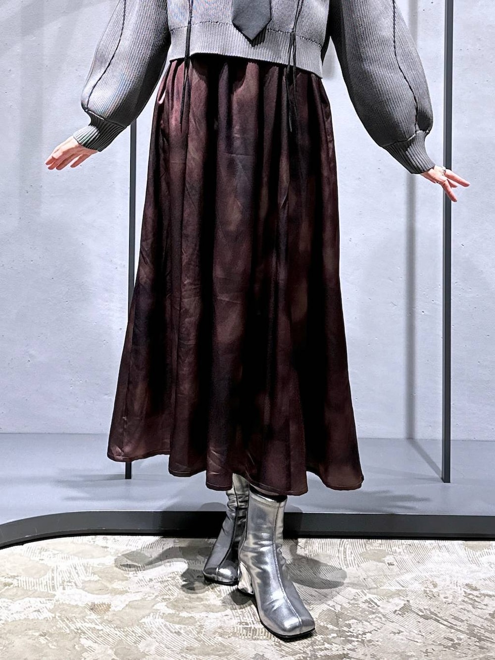 ブラック系のネクタイ、シルバー系のブーツ、グレー系のニット/セーターを着用したレディースの冬コーディネートの6枚目の写真