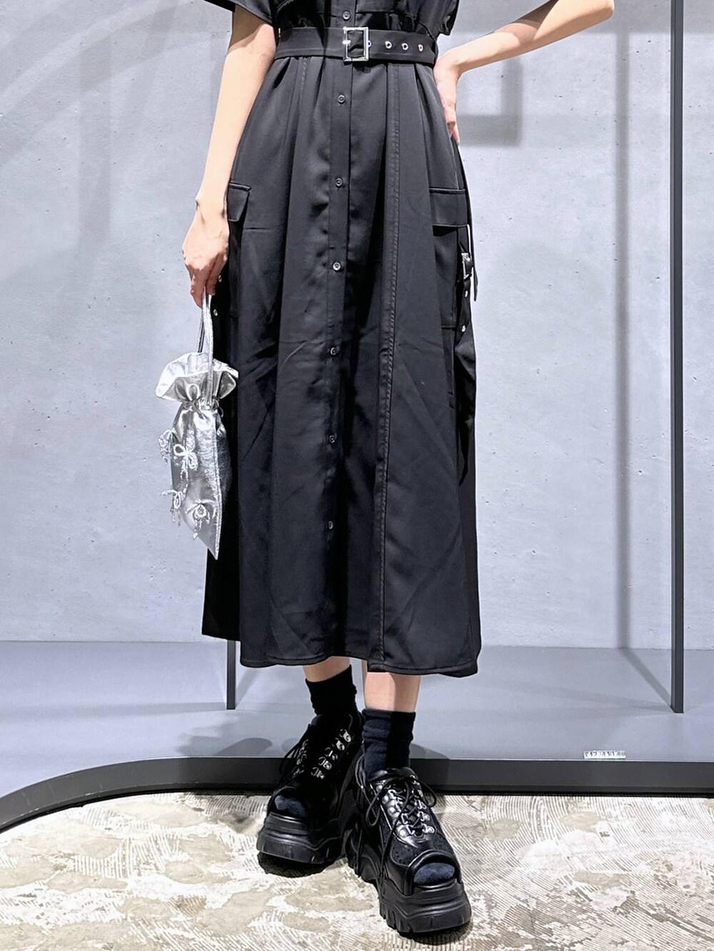 ブラック系のサンダル、ブラック系のワンピース、シルバー系のショルダーバッグを着用したレディースの夏コーディネートの6枚目の写真