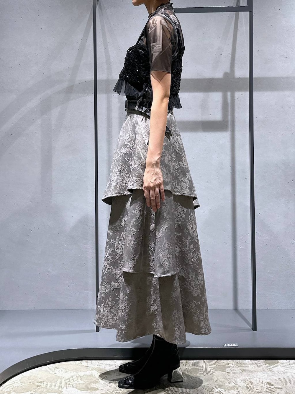 ブラック系のサンダル、ブラック系のチューブトップ、グレー系のスカートを着用したレディースの夏コーディネートの3枚目の写真