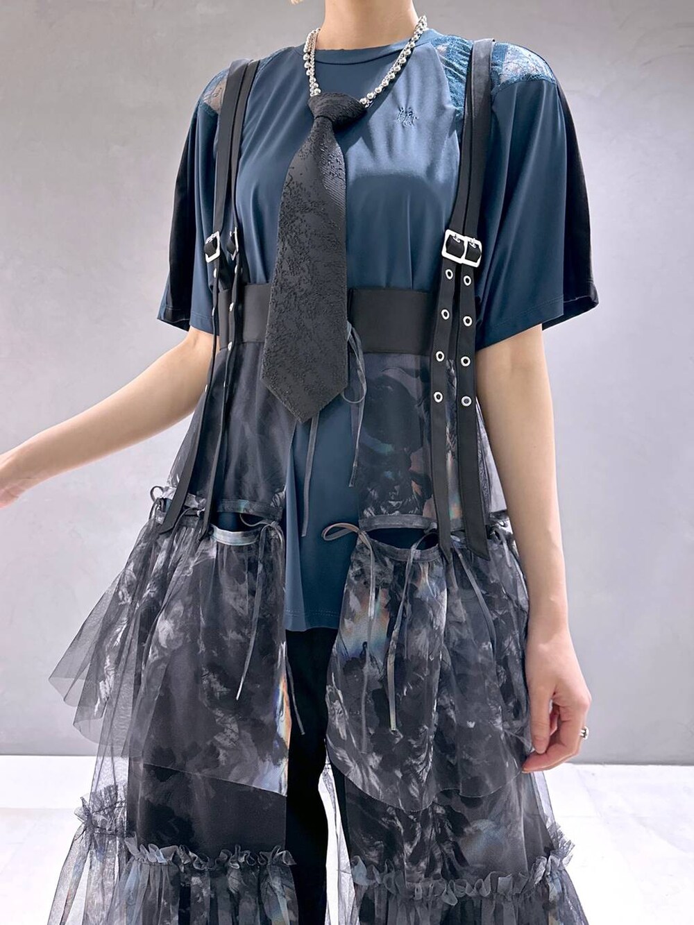 ブラック系のネクタイ、ブラック系のサンダル、グレー系のスカートを着用したレディースの春コーディネートの6枚目の写真