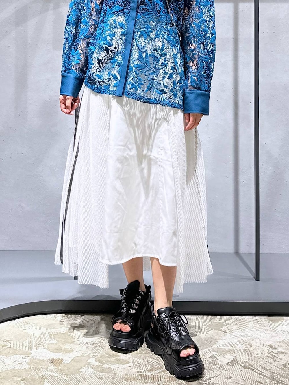 ブルー系のシャツ/ブラウス、ホワイト系のスカート、ブラック系のサンダルを着用したレディースの夏コーディネートの6枚目の写真