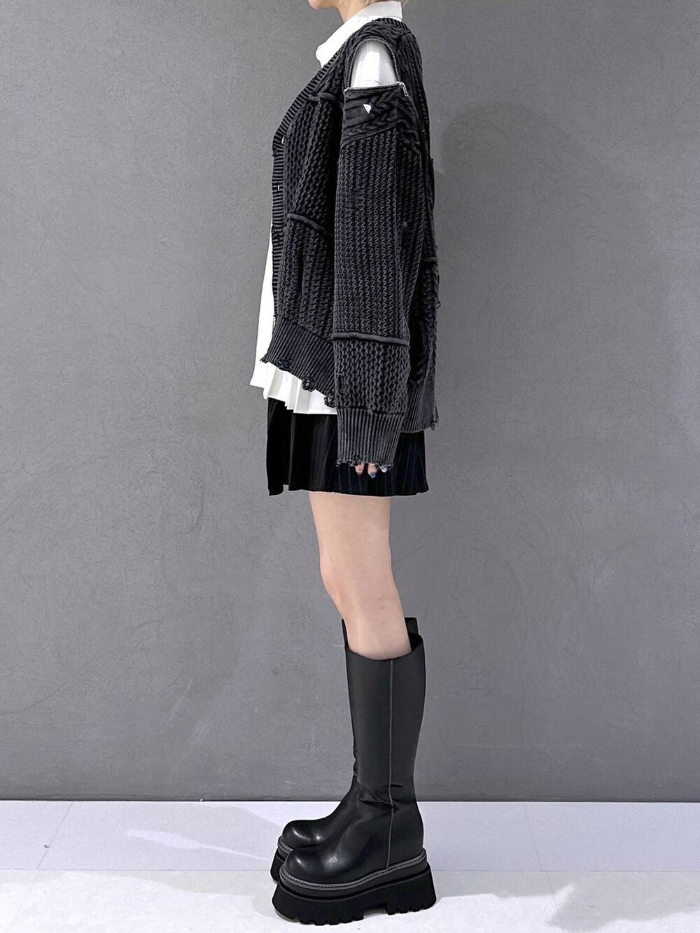 ブラック系のその他パンツ、ブラック系のカーディガン/ボレロ、ブラック系のブーツを着用したレディースの秋コーディネートの2枚目の写真