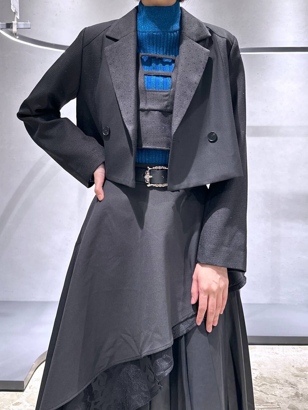 ブラック系のスカート、ブルー系のニット/セーター、ブラック系のブーツを着用したレディースの秋コーディネートの5枚目の写真