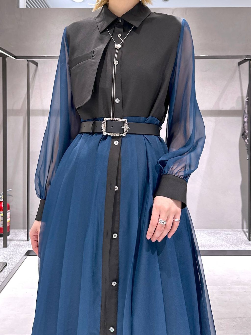 シルバー系のサンダル、ブラック系のワンピース、ホワイト系のスラックスを着用したレディースの春コーディネートの5枚目の写真