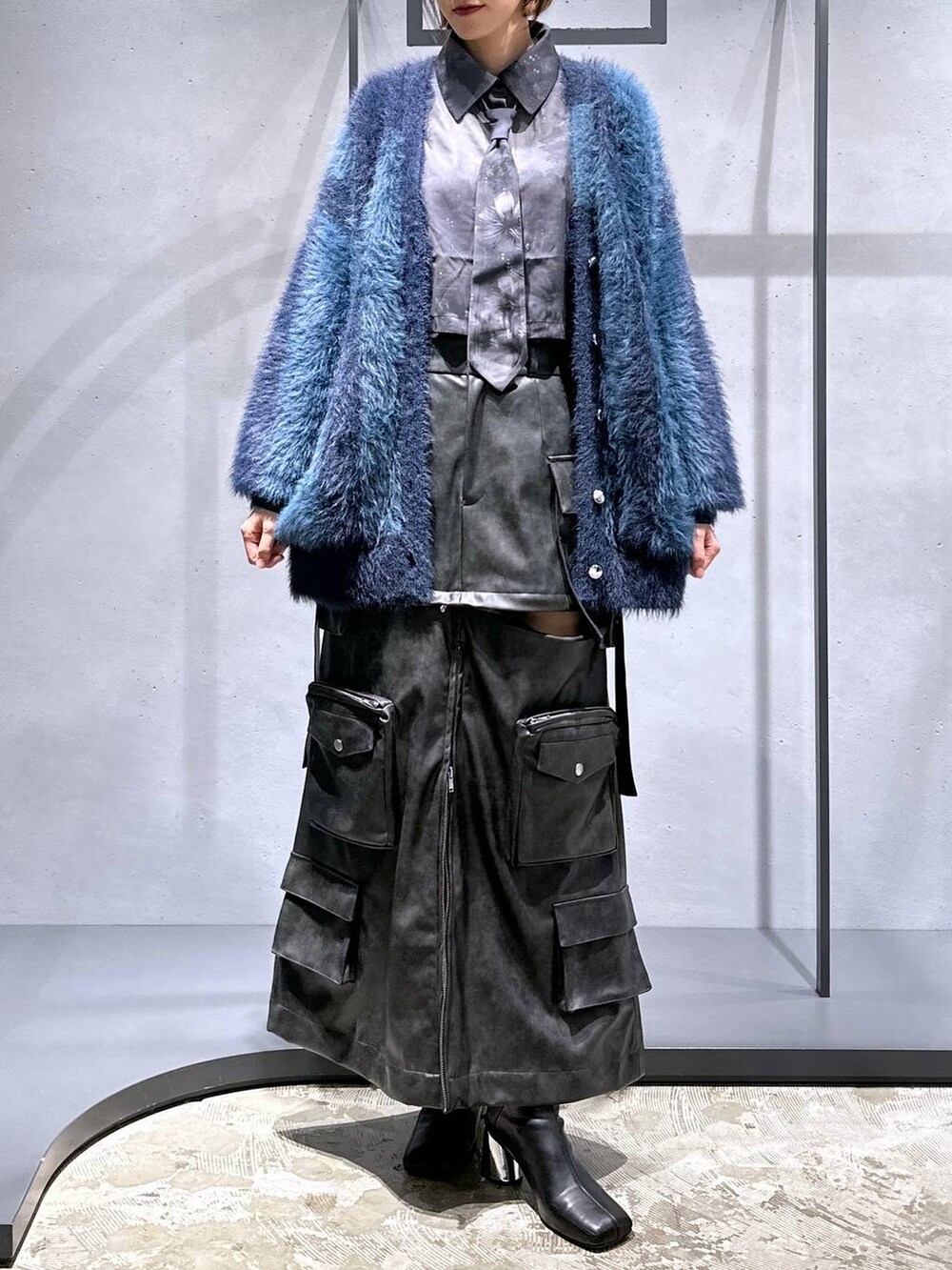 ブルー系のカーディガン/ボレロ、ブラック系のブーツ、ブラック系のシャツ/ブラウスを着用したレディースの秋コーディネートの4枚目の写真