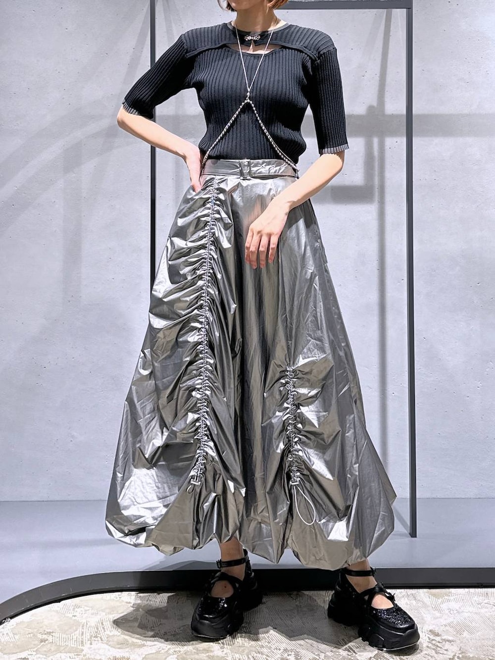 ブラック系のニット/セーター、ブラック系のスニーカー、シルバー系のスカートを着用したレディースの夏コーディネートの4枚目の写真