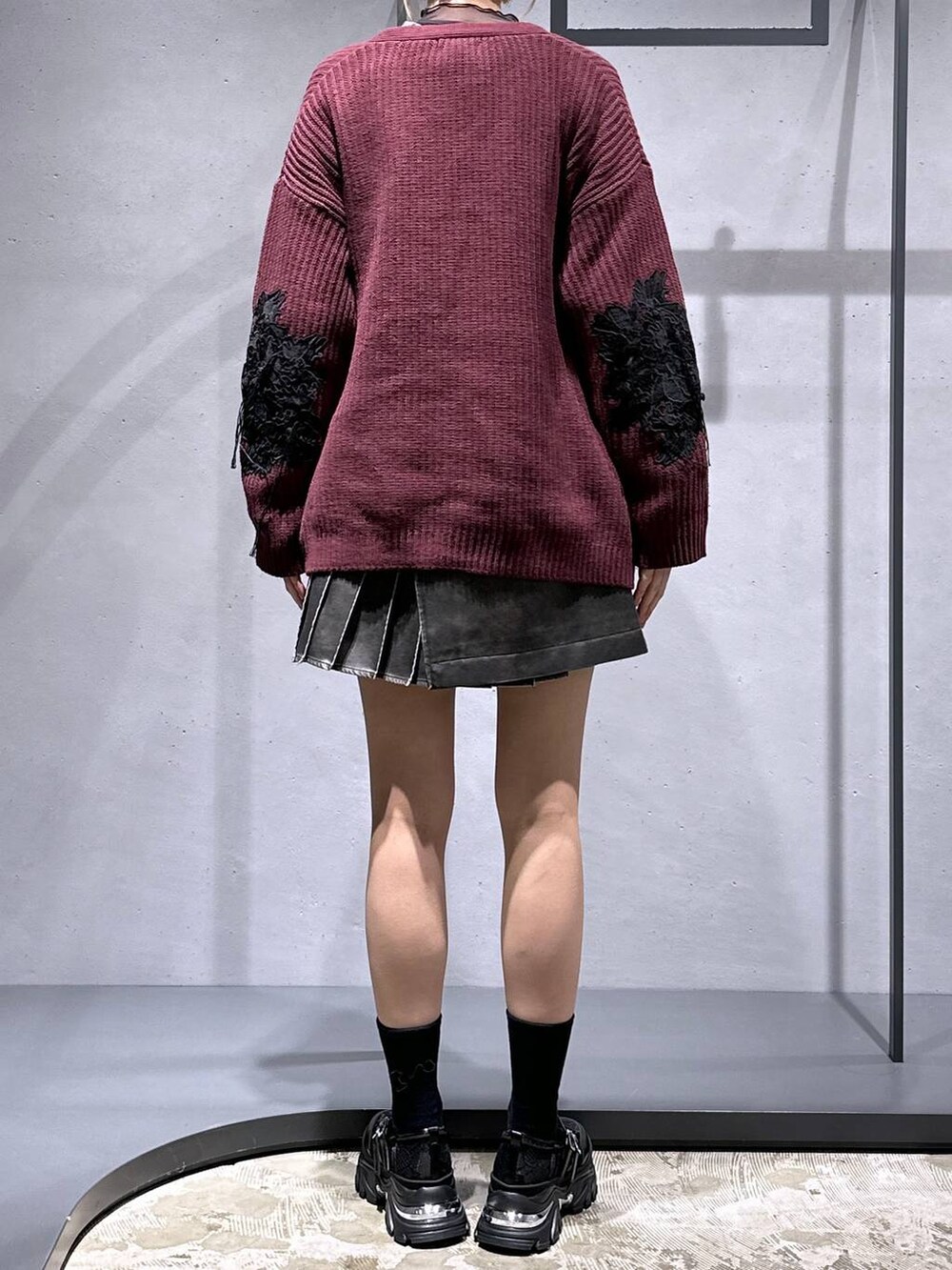 レッド系のカーディガン/ボレロ、ブラック系のスウェット、ブラック系のスニーカーを着用したレディースの冬コーディネートの3枚目の写真
