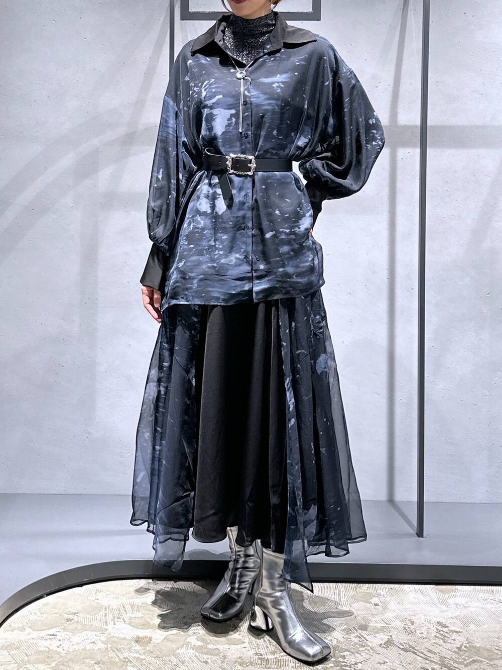 シルバー系のブーツ、ブラック系のニット/セーター、ブラック系のスカートを着用したレディースの秋コーディネートの4枚目の写真