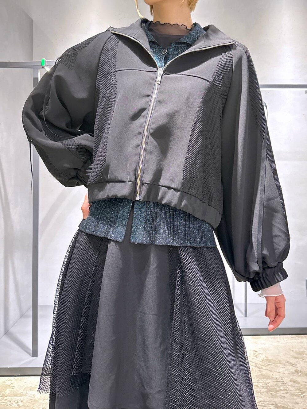 グリーン系のカーディガン/ボレロ、ブラック系のTシャツ/カットソー、ブラック系のスニーカーを着用したレディースの冬コーディネートの5枚目の写真