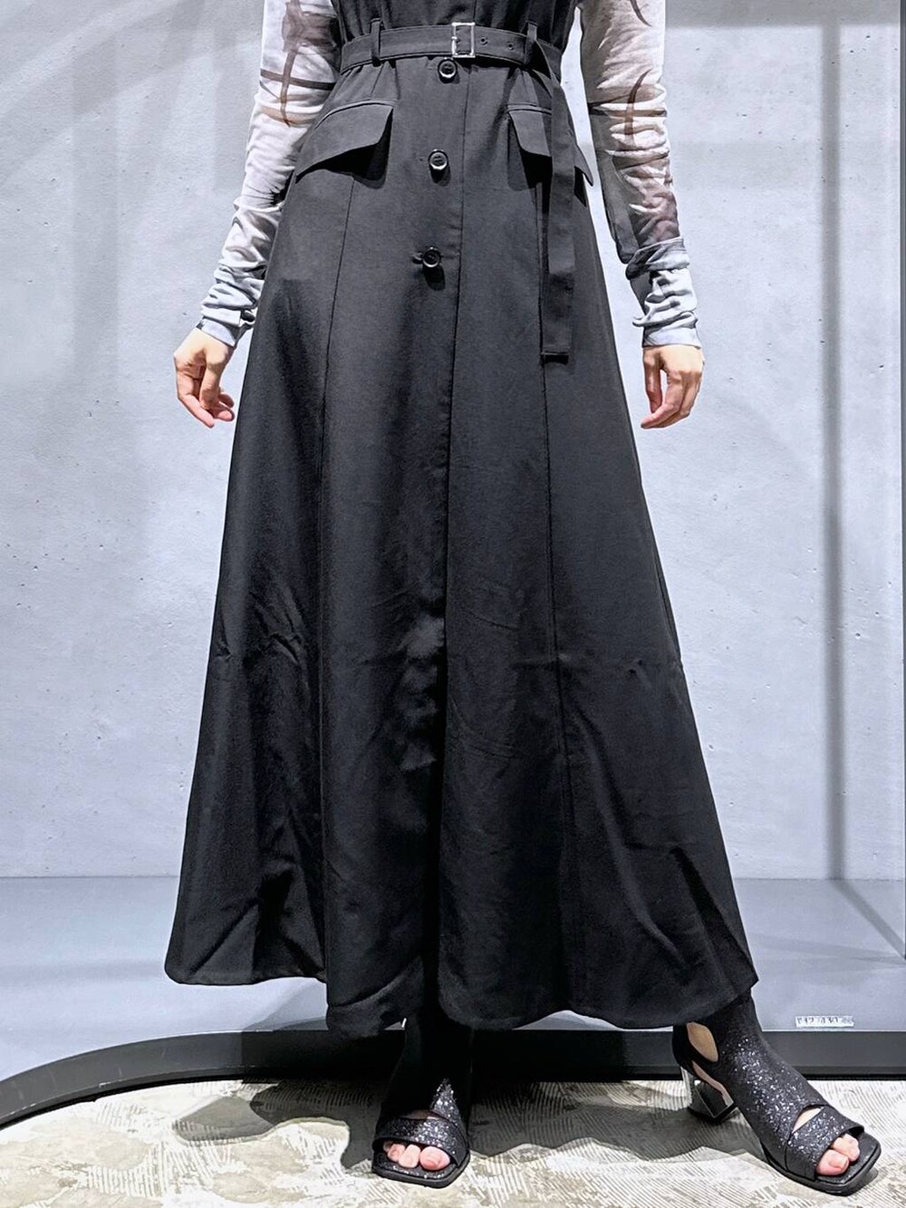 ブラック系のサンダル、ブラック系のジャンパースカート、ホワイト系のTシャツ/カットソーを着用したレディースの夏コーディネートの9枚目の写真