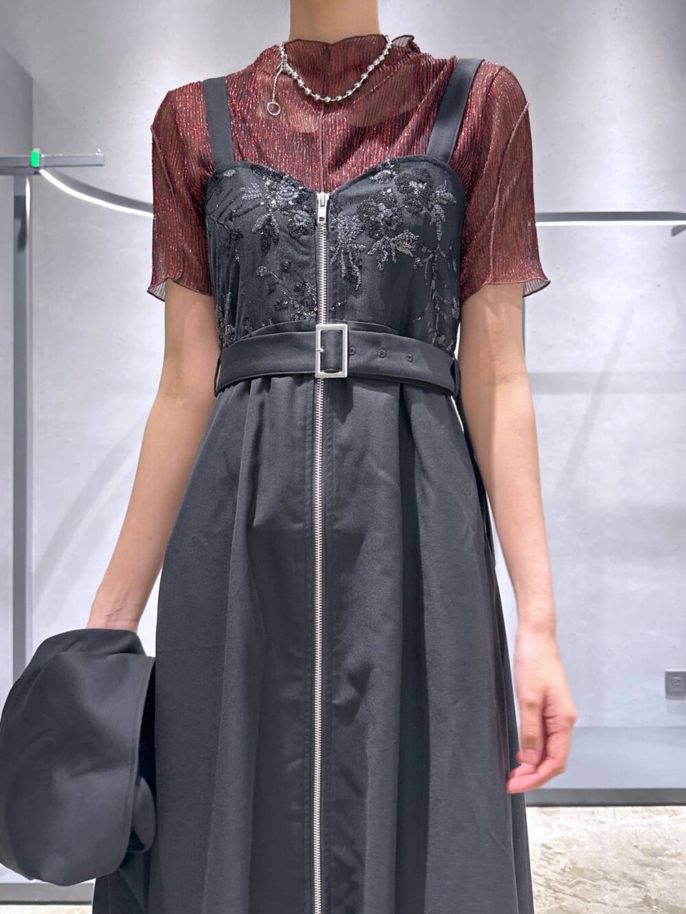 ブラック系のサンダル、レッド系のTシャツ/カットソー、ブラック系のジャンパースカートを着用したレディースの夏コーディネートの5枚目の写真