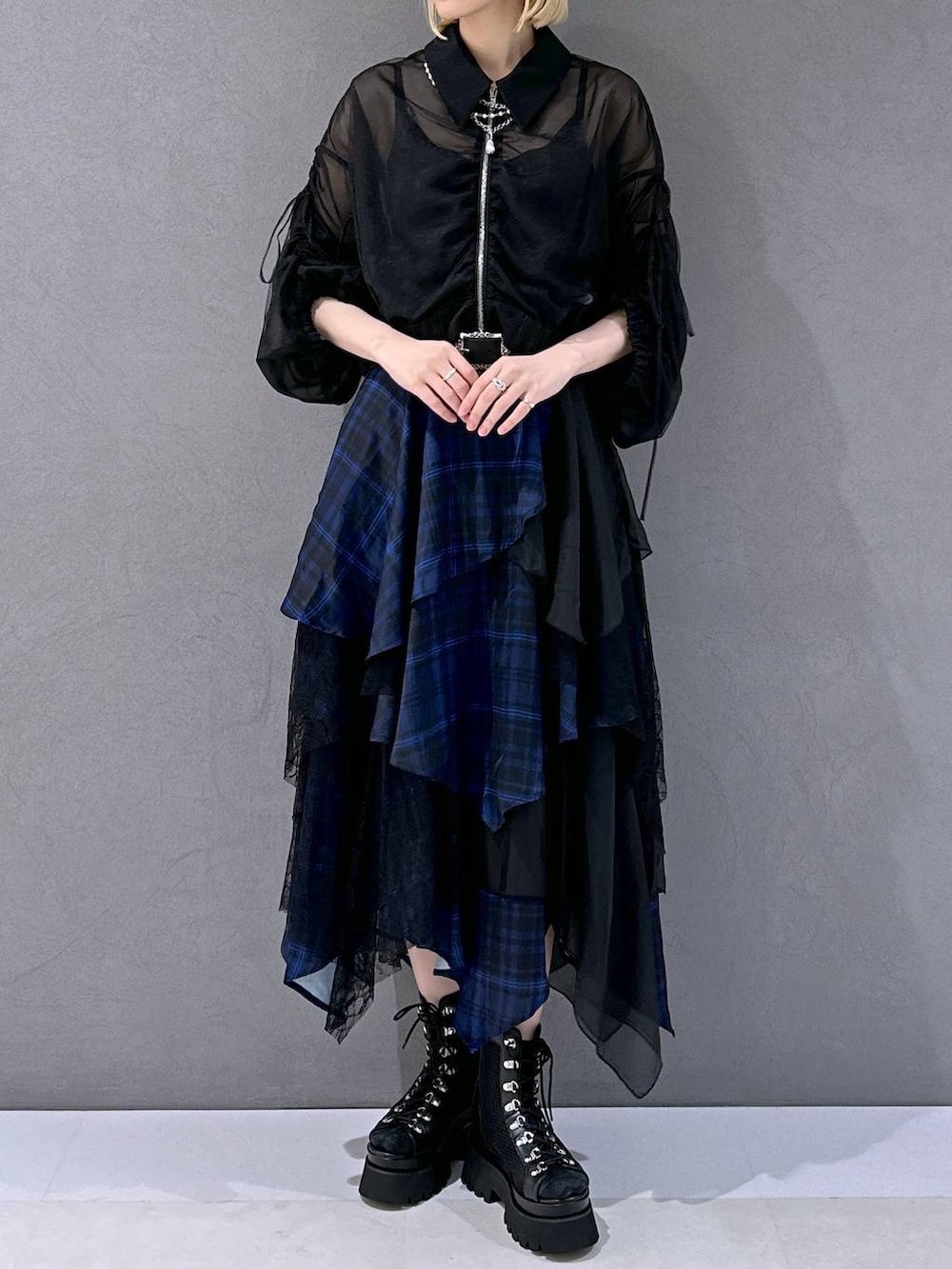 ブラック系のサンダル、ブルー系のスカート、ブラック系のブルゾンを着用したレディースの夏コーディネートの4枚目の写真