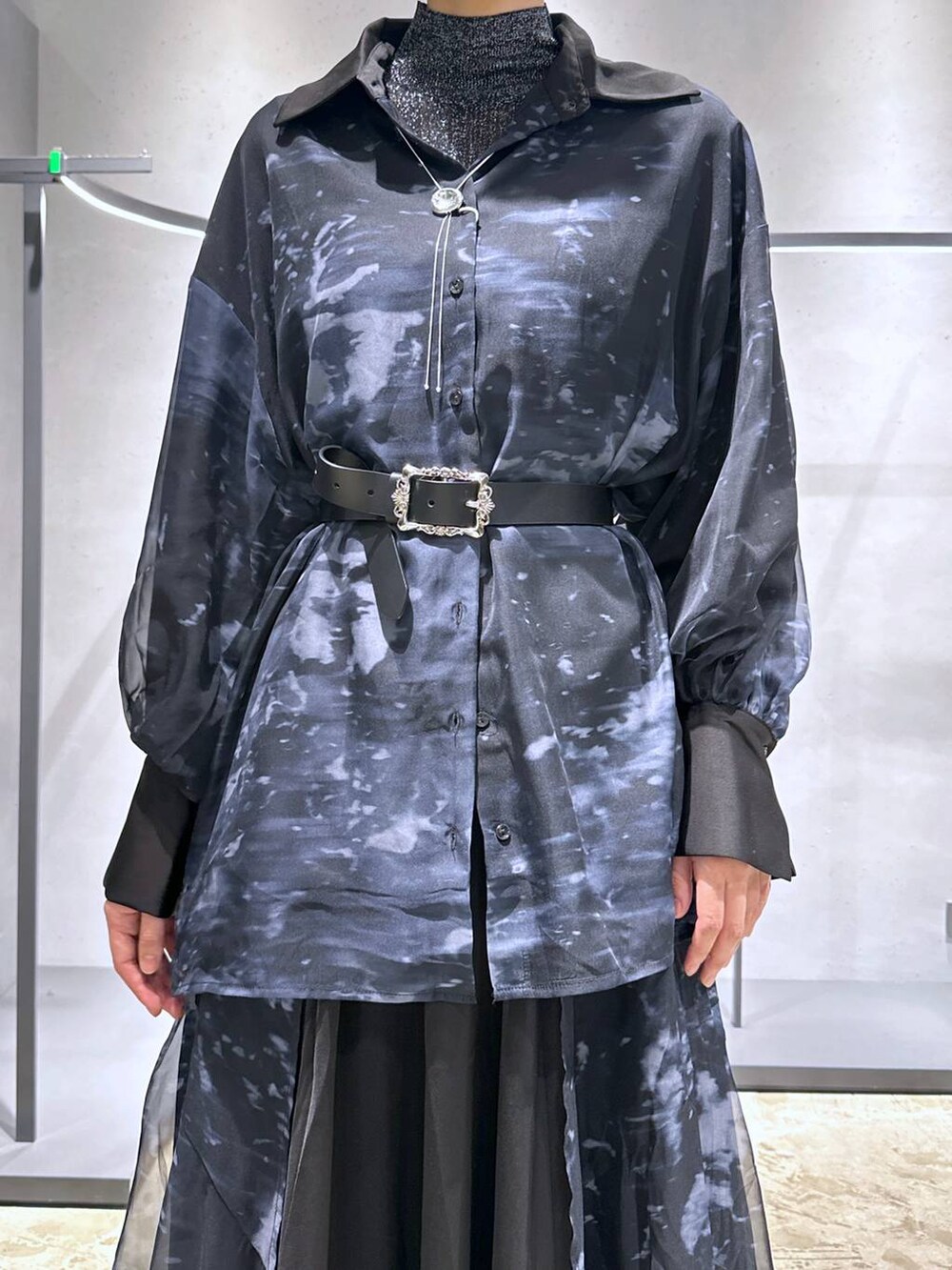 シルバー系のブーツ、ブラック系のニット/セーター、ブラック系のスカートを着用したレディースの秋コーディネートの5枚目の写真