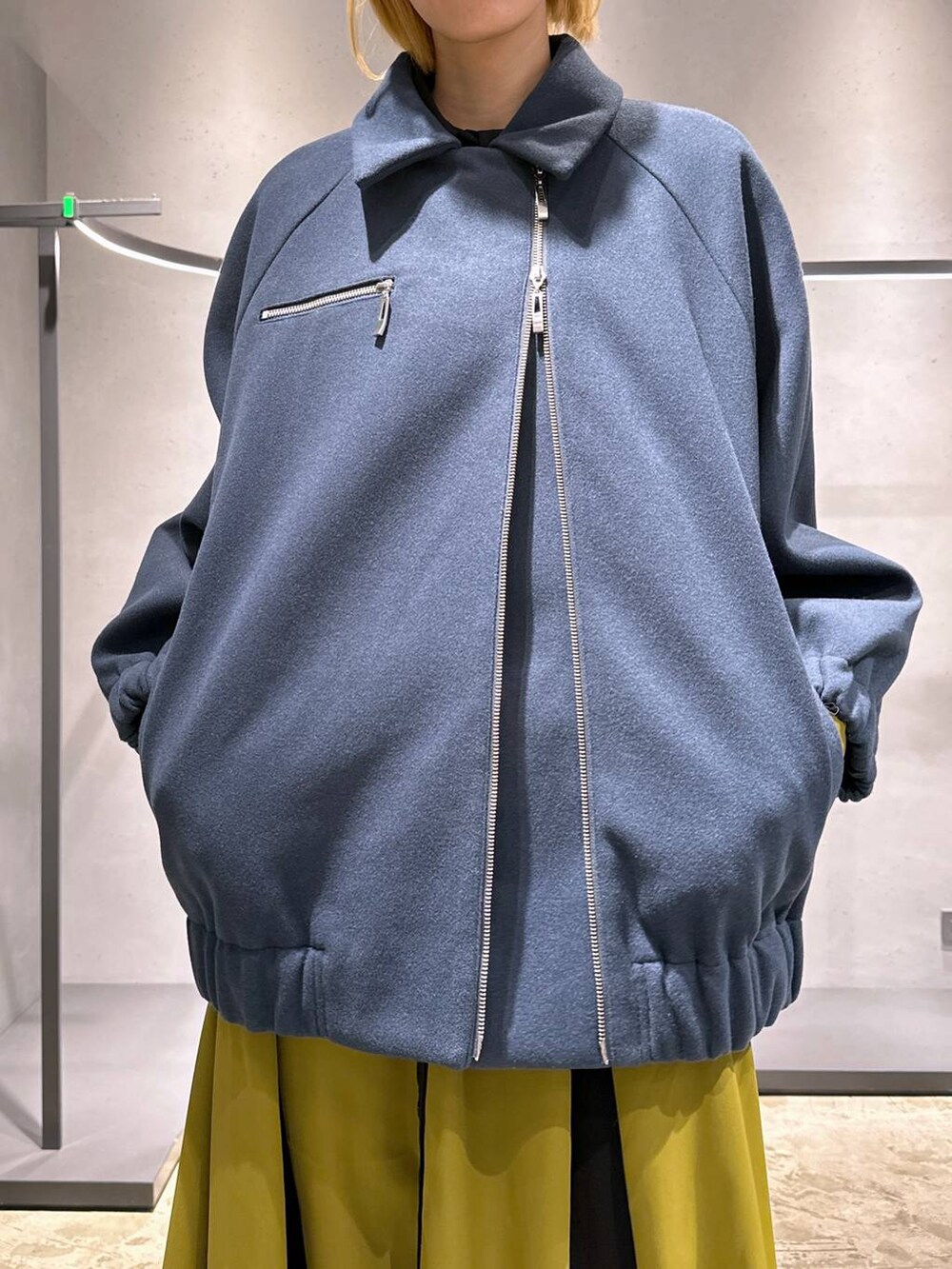 ブラック系のブーツ、ブルー系のブルゾン、イエロー系のワンピースを着用したレディースの冬コーディネートの5枚目の写真