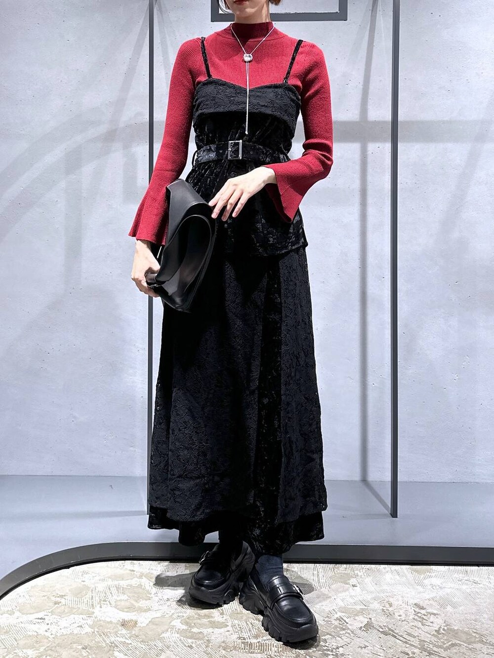 レッド系のニット/セーター、ブラック系のローファー、ブラック系のベストを着用したレディースの夏コーディネートの4枚目の写真