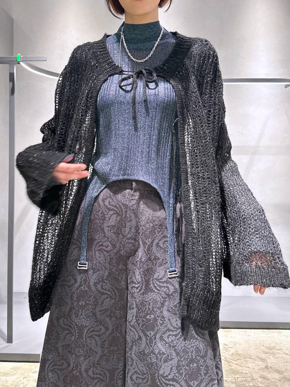 ブラック系のニット/セーター、シルバー系のブーツ、ブルー系のニット/セーターを着用したレディースの秋コーディネートの5枚目の写真