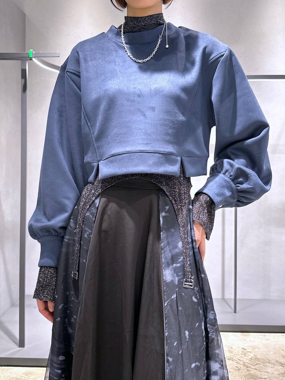 シルバー系のブーツ、ブルー系のスウェット、ブラック系のスカートを着用したレディースの秋コーディネートの6枚目の写真