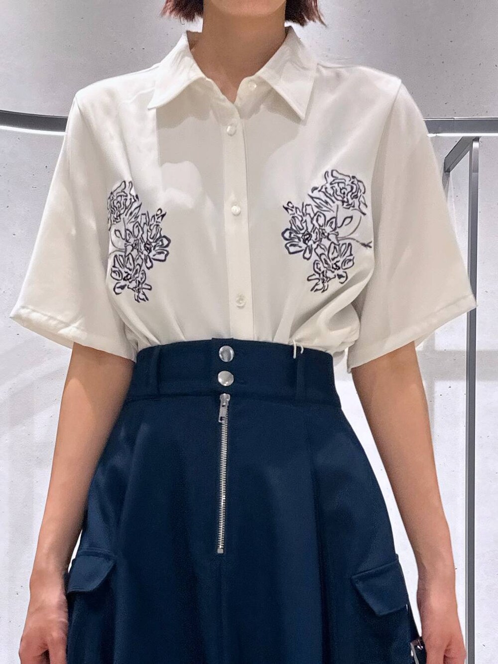 ブラック系のサンダル、ブルー系のスカート、ホワイト系のシャツ/ブラウスを着用したレディースの春コーディネートの2枚目の写真